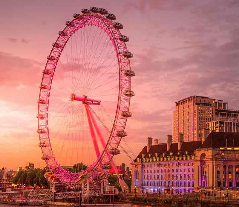 Giant ferris wheel against an orange sky.